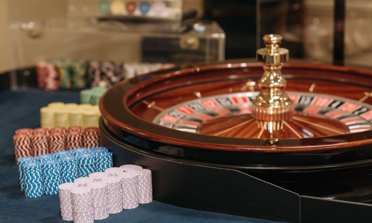 Roulette wheel and several casino chip stacks for comparing NZ$15 deposit casinos