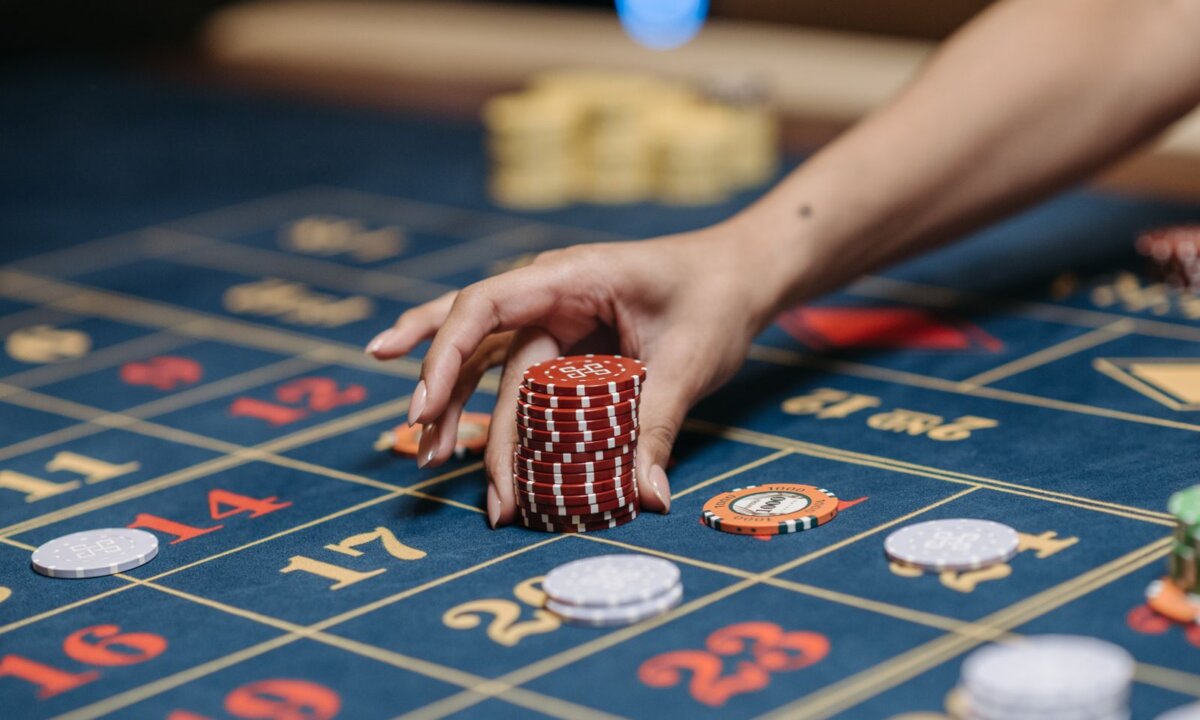 Hand placing casino chips on a roulette table for the NZ$2 deposit steps